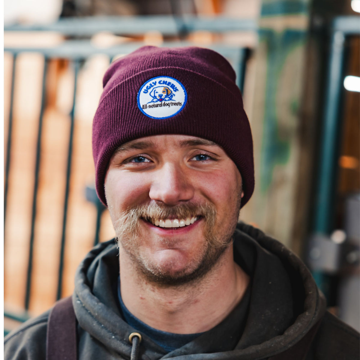 Man wearing a maroon Ugly Chews beanie