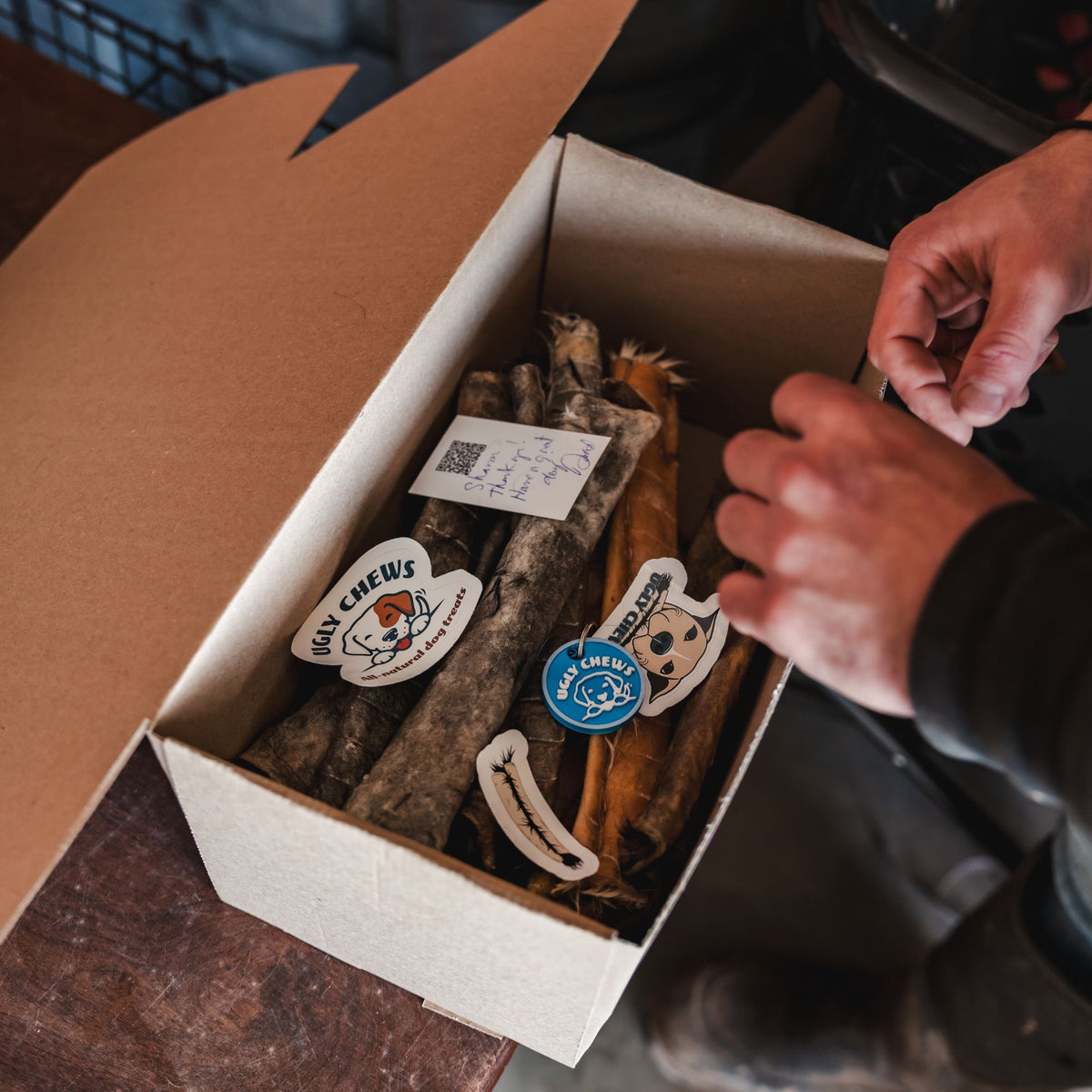 Ugly Chews shipping box with beef hide chews and stickers